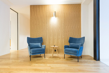 Fototapeta premium Interior of a modern hotel lounge, resting area with two blue armchairs