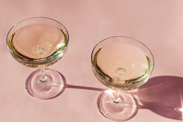 Two glasses of sparkling wine on the pink table