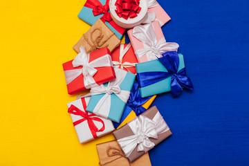 many multi-colored holiday gifts on a yellow and blue background