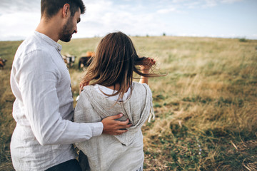 Obraz premium The guy hugs the girl. Rear view