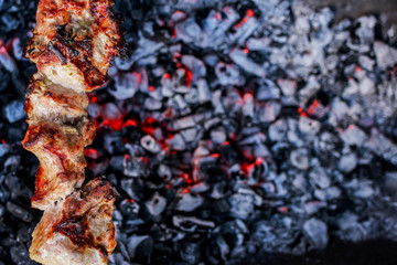Grilled delicious pork kebab, shashlik or kebab, skewer, on the grill closeup, copy space