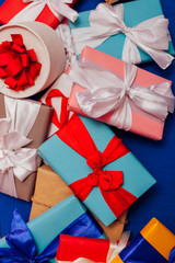 many multi-colored gifts for the holiday on a blue background
