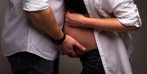 Young attractive couple: pregnant mother and happy father.Loving future couple expecting a baby.