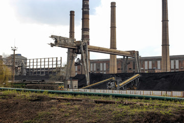 A mountain of coal and a crane at a thermal power plant