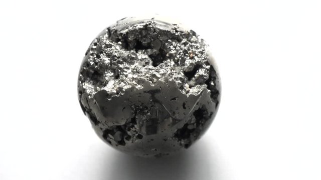 Beautiful iron ball of natural pyrite rotation, revolves around itself and its axis On a white background. Golden and golden ball or pyrite sphere. Сollection Natural stones, crystals. Minimalism
