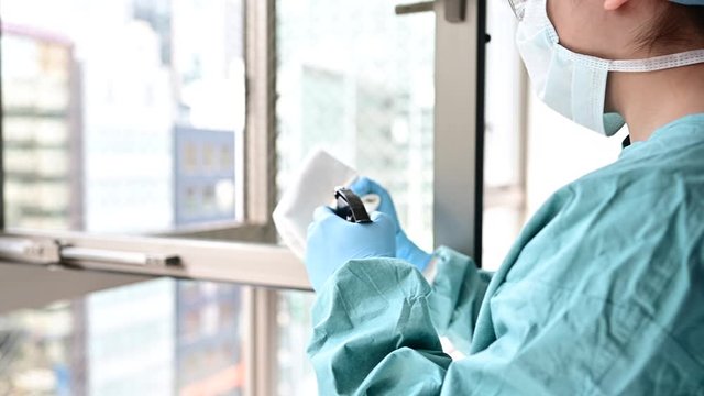 ウイルス感染防護服を着た人が除菌作業をしている
