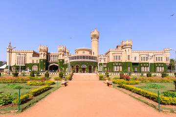 Beautiful exterior view of Bangalore Palace with a garden in front.