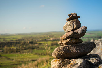 Fototapeta na wymiar stack of stones with sky and montain background