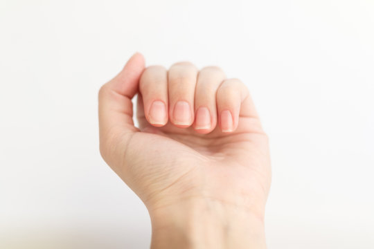 Close up woman hand with nails form of soft square holds something in fingers. Female keeps virtual object. Nail care at home.