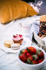 Summer picnic in the park with strawberries, muffins and macaroons.