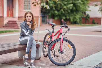 Young woman athlete cyclist resting in the park