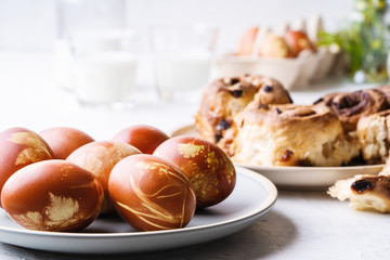 Easter brunch table. Cinnamon buns,  eggs dyed with onion shells and springtime  plants, sustainable living