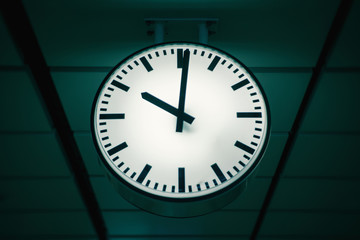 public indoor clock in train station, clock shows time for passengers or commuters, shallow depth of field