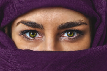 close up female eyes woman portrait with purple cloth  covered her face