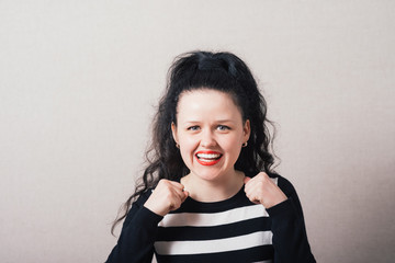 Woman hands in a fist, a gesture of victory, strength. Gray background