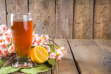 Indian Nannari sherbet drink, or refreshing summer lemonade cocktail, infused beverage with sarsaparilla roots, nannari syrup, herbs, citrus and spices, Wooden background copy space