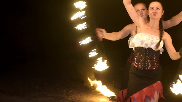 People perform a fireshow at night 
