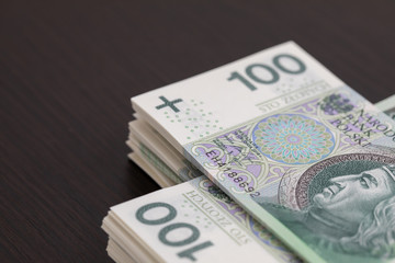 Banknotes evenly distributed on a dark brown desk ready for use.