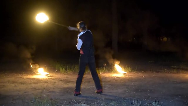 Fireartist performs firejuggling at fireshow