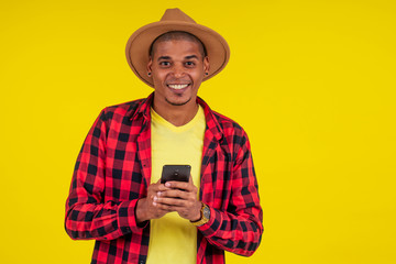 Smart casual man using smartphone in studio yellow background