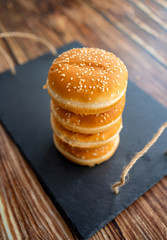 buns with sesame for burgers. black stone tray.