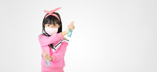 Asian child girl are strengthening to overcome the virus by wearing a mask and carrying alcohol bottles for washing hands, cleaning or spraying infected items. Covid-19
