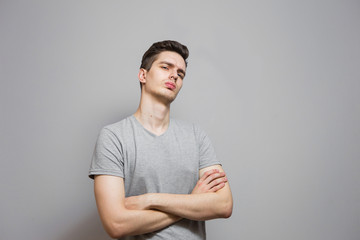 A guy in a gray T-shirt with emotions on his face.