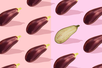 Flat lay colorful pattern with eggplant on pastel pink background. Trendy mockup or wallpaper. Minimal healhty lyfestyle concept with sharp shadows.