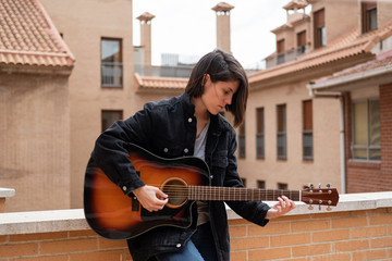 A young girl takes online guitar lessons from her home