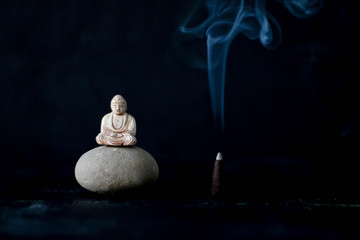 .Buddha on a stone near aroma sticks