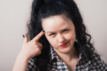 young woman thinks his finger to his temple