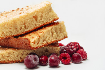 Semolina cake with raspberries and cherries isolated on white background