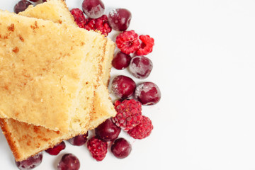 Semolina cake with raspberries and cherries isolated on white background