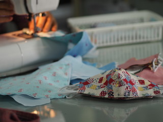 Woman use sew machine to sewing face medical mask protective against during the dust PM 2.5, coronavirus Epidemic, virus covid-19 work Home at home made DIY