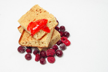 Semolina cake with raspberries cherries and strawberry jam isolated on white background