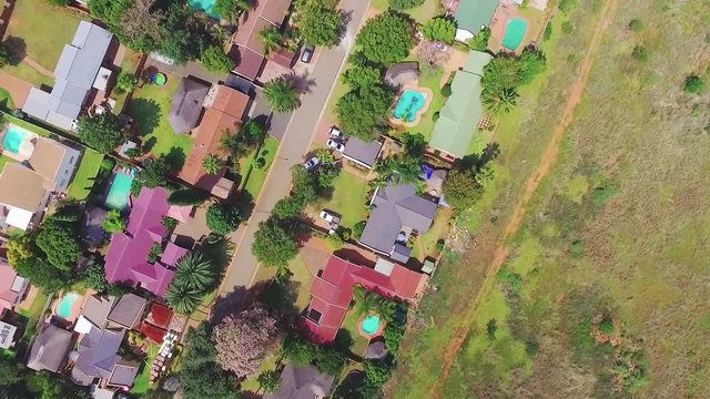 Drone footage of a general suburb in South Africa. The drone camera is facing downwards whilst it is descending. 