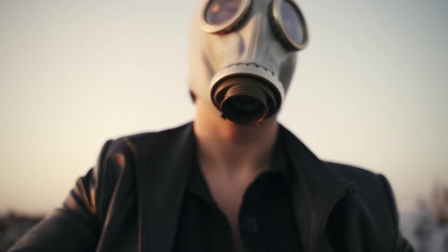 face in gas mask close-up on sky background