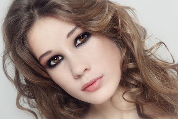 Obraz premium Vintage style close-up portrait of young beautiful fresh girl with curly hair and smoky eye makeup
