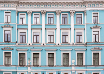 Vintage architecture classical light blue  facade with columns, vases and meander. Front view.