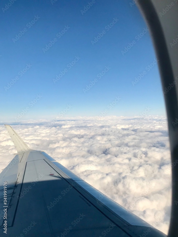 Wall mural beautiful view out of the airplane window inside the cabin of a business flight: the aircaft's wing 