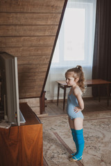 Little cute girl is practicing gymnastics at home. Online training. Quarantine. Stay at home.