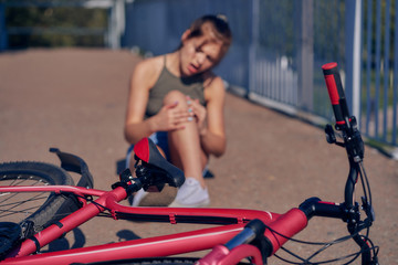 A girl fell in the city from a bicycle, examines a bruise.