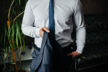 Stylish young man buttoning the cuff links on the sleeves. Style