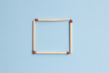 A square of matches on a blue background. Top view. Mock up. Flat lay composition