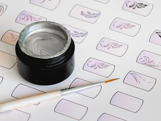 Training in painting monograms for manicure. Training cards for manicure, close up. 