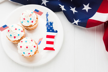 Obraz premium Top view of cupcakes on plate with statue of liberty and american flags