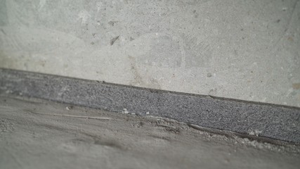 Worker glues damper tape before laying the floor. Reinforcing tape for drywall. Damper tape for screed