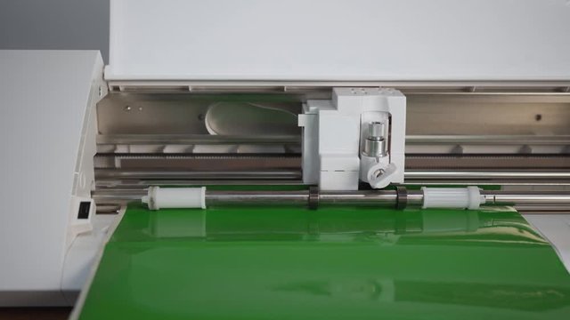 small cutting plotter. Plotter cuts green vinyl slowly