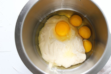 Flour and eggs in a metal bowl. Homemade cake. Concept of homework during the quarantine period.