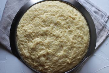 Yeast dough in a large glass bowl. Homemade cake. Concept of homework during the quarantine period.